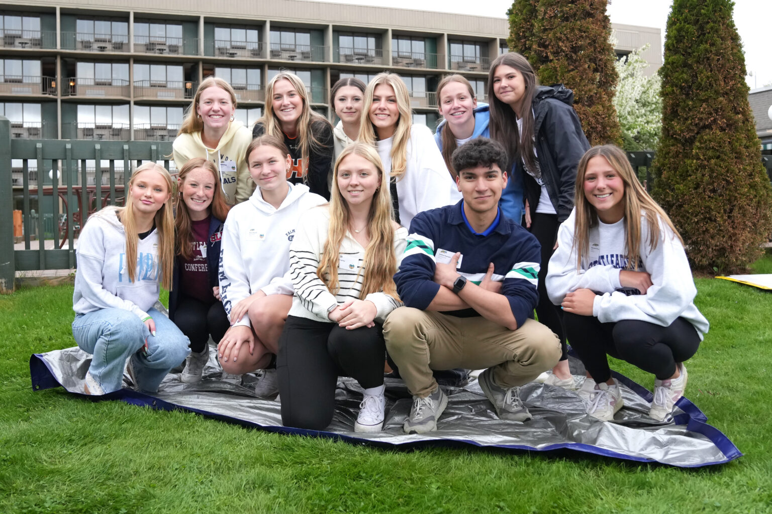 A group of smiling North Country students gathered outdoors