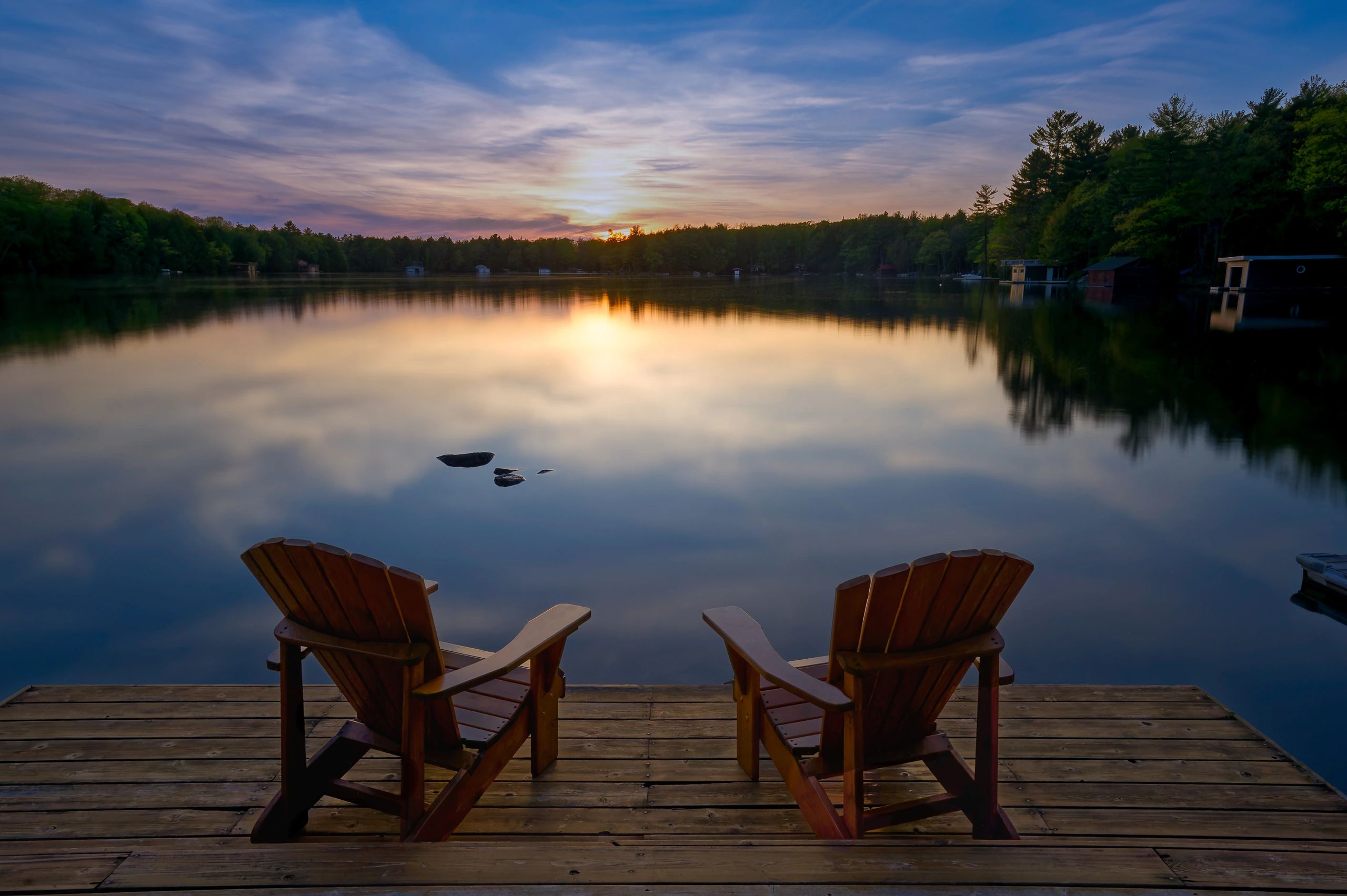 Adirondack chairs on a dock overlooking a North Country lake