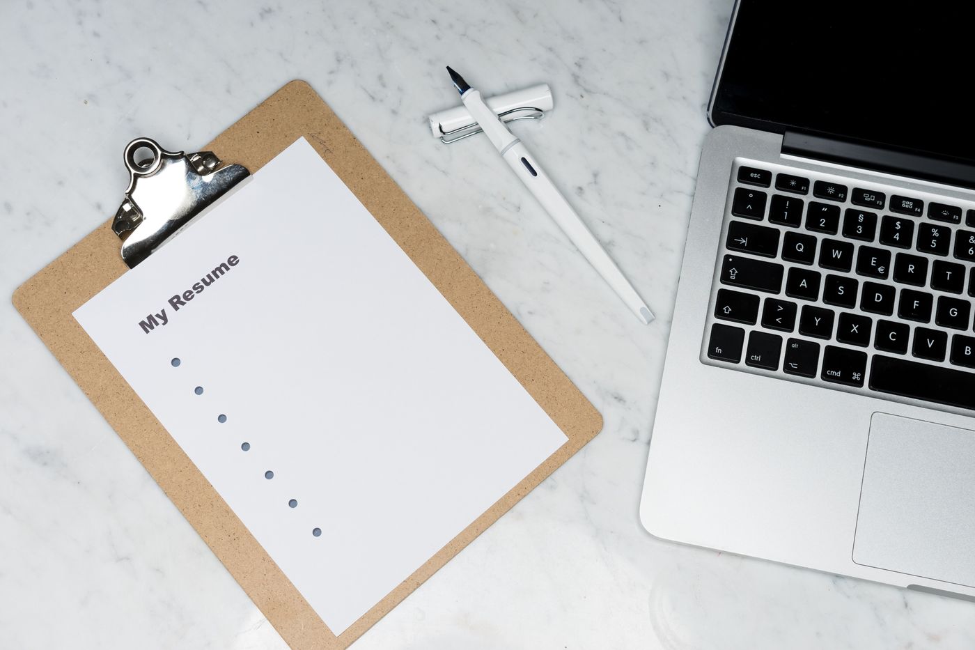 Résumé on a clipboard next to a laptop
