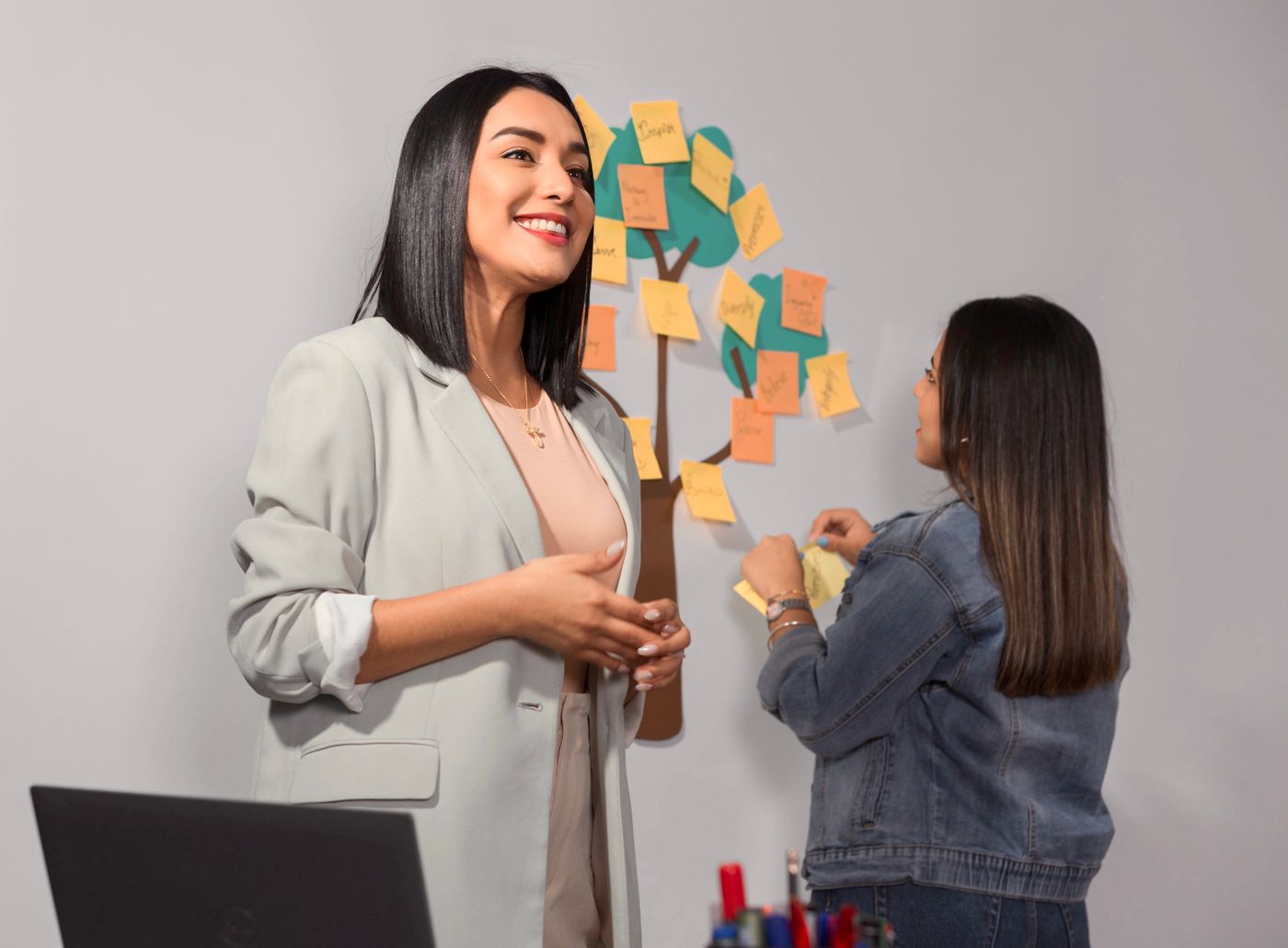 Two educators planning together with sticky notes on a wall