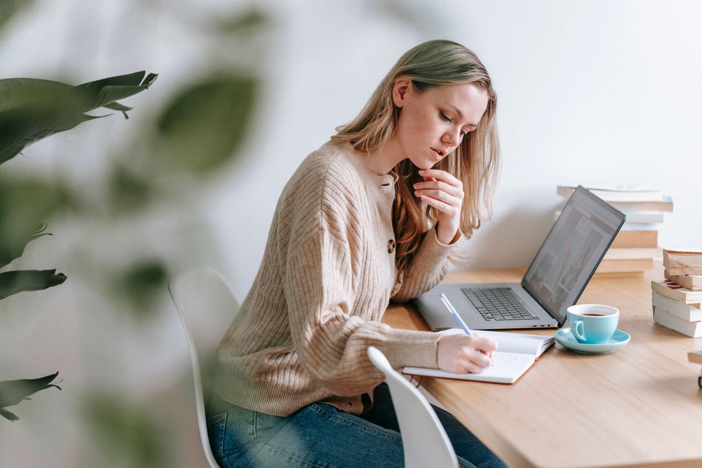 Candidate researching at a desk with a laptop and notebook