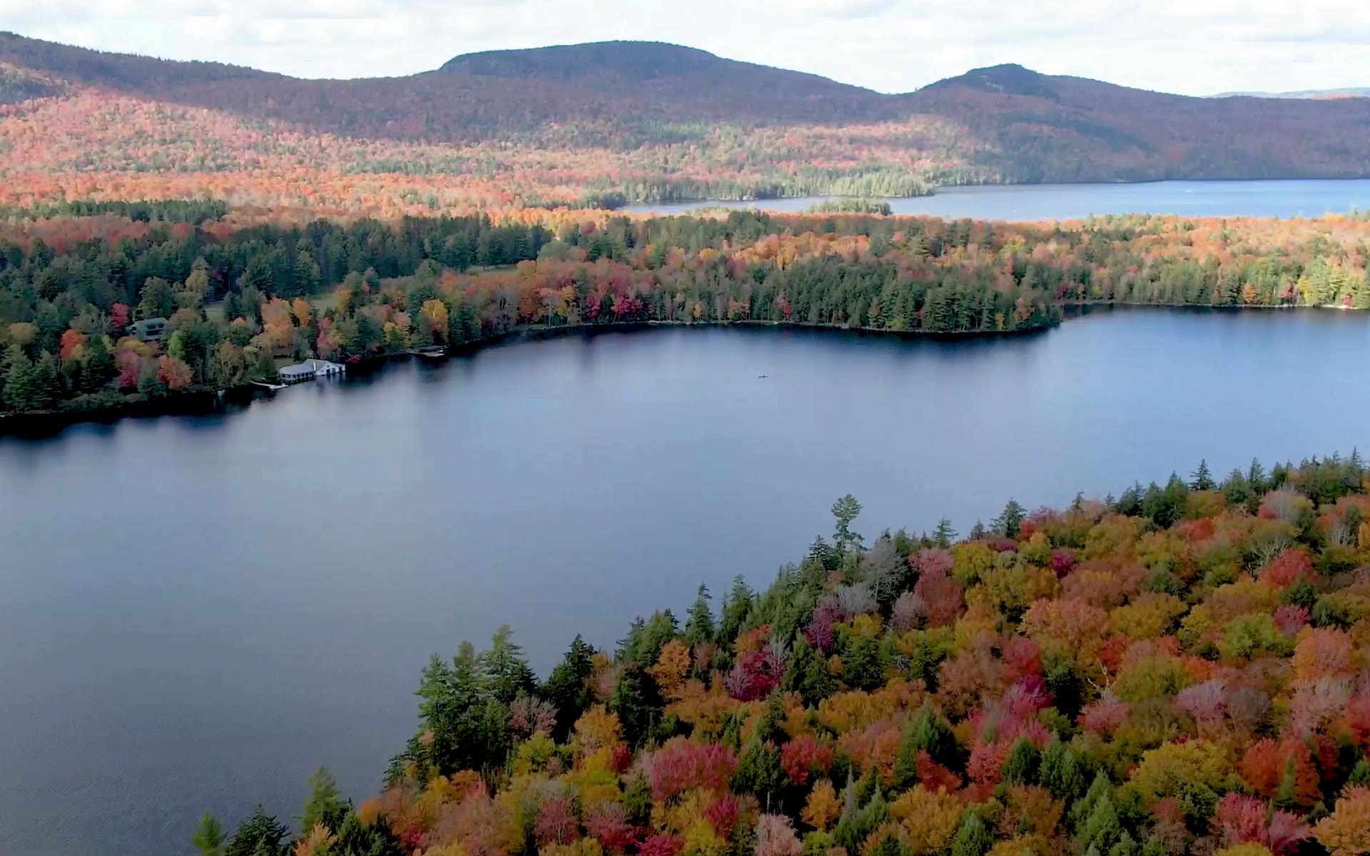 Aerial view of a lake surrounded by fall foliage