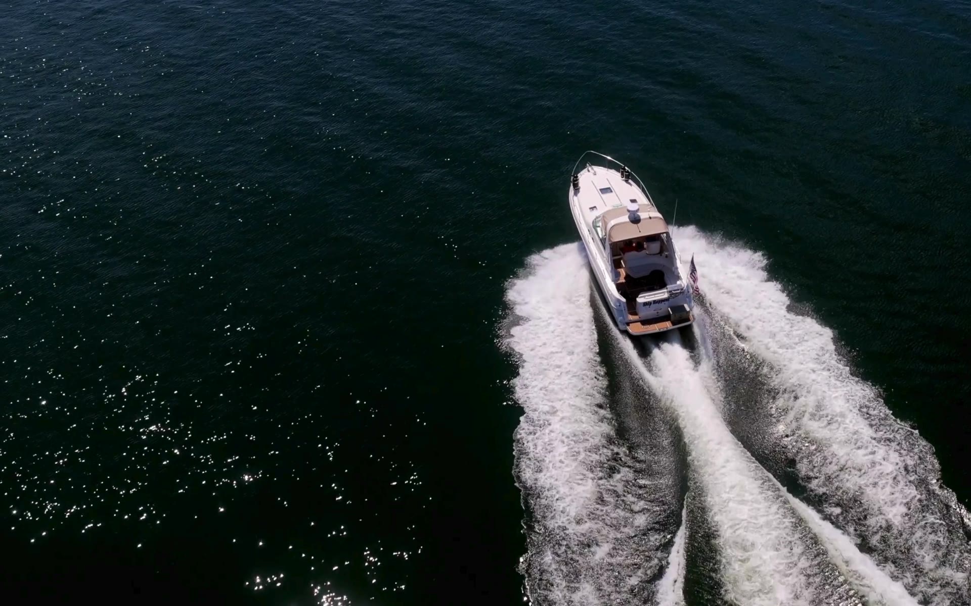 Boat cutting across a deep blue lake
